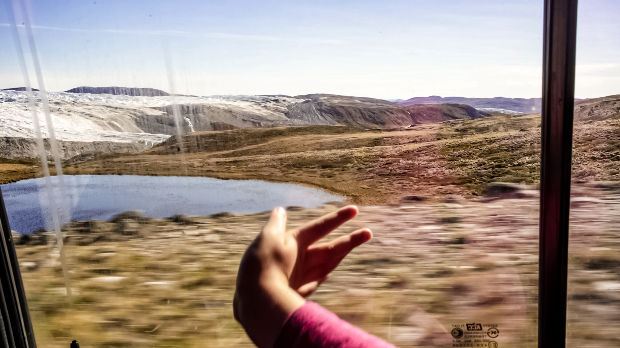 child's hand on window driving up to polar ice cap, greenland